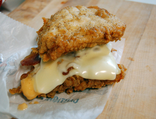 KFC Double Down Sandwich Two pieces of bacon and two slices of cheese smothered with the Colonel’s Sauce with two fried chicken patties as buns. (via foodgeekery)